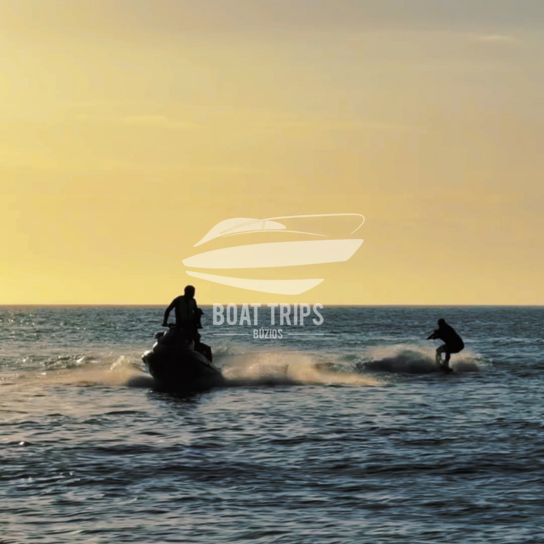 Wakeboard puxado por jet ski ao pôr do sol